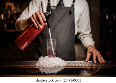 Barman Pouring Alcoholic Sparkling Water Into A Glass With Sweet Red Berry Summer Cocktail On The Bar Counter