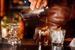 Barman Nalévá čerstvý Alkoholický Nápoj Do Sklenic S Kostkami Ledu Na Barovém Pultu