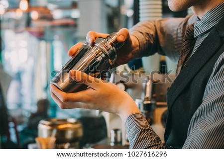 Barman In Pub Holding Shaker. Focus Is On Shaker.