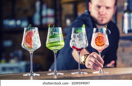 Barman In Pub Or Restaurant  Preparing A Gin Tonic Cocktail Drinks In Wine Glasses.