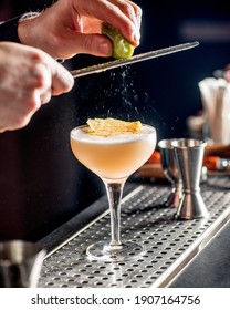 Barman Rubs Lime Zest On Cocktail. Bartender Is Preparing A Cocktail For Serving.Finishing A Cocktail. Mixology