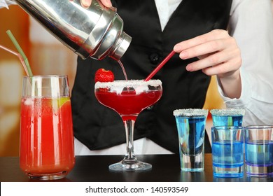 Barmen Hand With Shaker  Pouring Cocktail Into Glass, On Bright Background