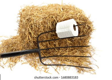 Barn Comfort, A Roll Of Toilet Paper On A Pitch Fork On A Hay Bale Isolated On White