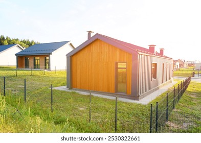 Barn House in village on sunset. Barn House with fence. Modern Architecture design house. Wooden Scandi home in rural. Modern Scandinavian Barnhouse. Contemporary barn as family house in suburb.  - Powered by Shutterstock