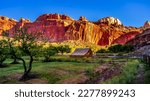 Barn in a meadow surrounded by red sandstone mountains in the Fruita settlement in Capitol Reef National Park, Utah, USA