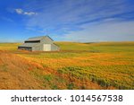 Barn in the middle of fields with blue sky background