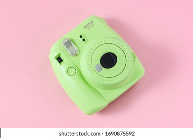 Barnaul, Russia - March 29, 2020: Green instant camera on pink background. Fujifilm instax mini 9.