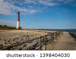 Barnegat Lighthouse on Long Beach Island, NJ, on a sunny spring day with blue sky dotted with clouds