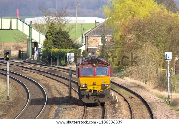 BARNETBY, LINCOLNSHIRE, UK - MARCH 19, 2014:\
EWS-liveried DB Schenker Class 66 No. 66095 approaches Knabbs\
Crossing Bridge at Barnetby, working the 000E 14:59 Immingham\
T.M.D. to Doncaster\
L.I.P.