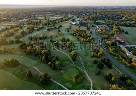 Similar – A tranquil aerial view of a lush golf course fairway, bathed in the warm glow of sunset. Ideal for themes of relaxation, nature, and sports, this image captures the peaceful beauty of the golfing experience.