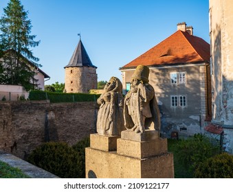 Baroque Stony Figures Of The Dwarf Cabinet Near Castle Of Nove Mesto Nad Metuji, Czech Republic. Castle Towers On Background. Dwarf Cabinet Is Mini Sculptures Created Baroque Sculptor In 18th Century