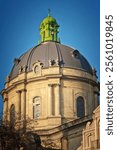 Baroque-style dome of the Dominican Church. Historical architecture with intricate details, columns, and bright green accents under a clear blue sky. Perfect for travel and heritage themes.