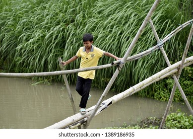 Barpeta, Assam, India. May 3, 2019.  Children Crossing A Bamboo Bridge  At Kayakuchi Village In Barpeta District Of Assam.