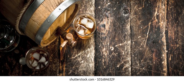 Barrel Of Scotch Whiskey With A Glass. On A Wooden Background.