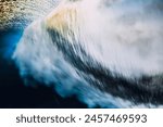 Barrel wave crashing in ocean with sunset or sunrise light. Underwater view of surfing wave with long shutter speed