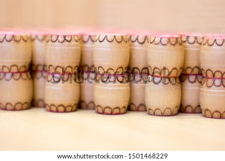 Barrels of lotto side view. Red numbers on wooden rounded shapes. Background from barrels of lotto. Macro shot of wooden products.