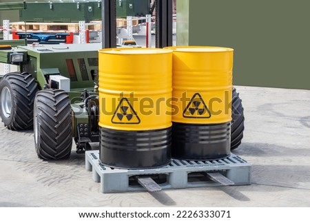 Barrels with radioactive products. Unmanned forklift. Machine for working in radioactive zone. Forklift for transportation of hazardous substances. Robot carries barrels of radioactive material