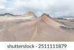 a barren desert landscape with a reddish-brown ridge running diagonally. A narrow path follows the ridge