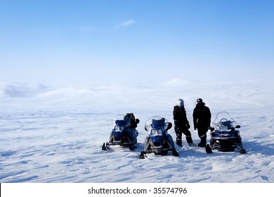 A Barren Winter Landscape With A Group Of People On A Snowmobile Expedition