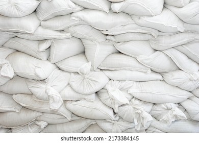 A barricade wall made of sandbags. Defense concept, Bags to strengthen the defensive structure during the battle. Protection in time of war. White sandbags as a background or texture.