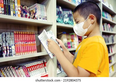 Barrie, Ontario, Canada - August 20, 2022 :  Cute Elementary Student Boy Reading Comic Book At A Bookstore During Summer Break. Summer Reading And Education Background.