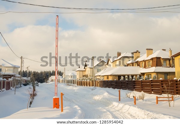 Barrier Gate Automatic system for\
security at the entrance to the cottage town. Winter sunny\
day