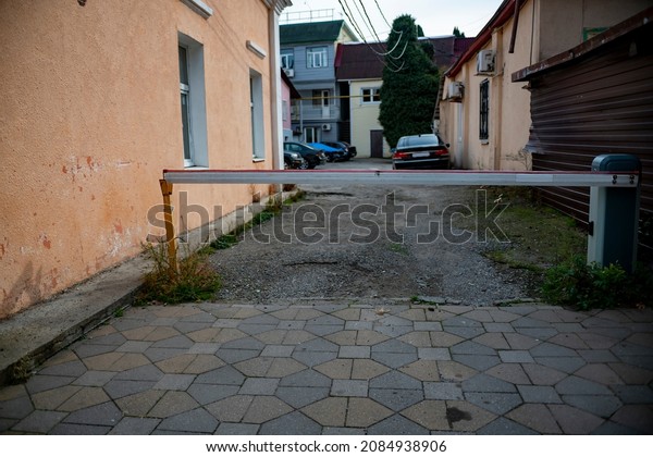 A barrier in a\
narrow street of a private dwelling. Fencing of passage and parking\
in a residential area.