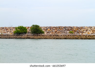 barrier and rock dam, protection seawater and wave at the estuary,stones to protect the shore from the surf of the sea waves . - Powered by Shutterstock