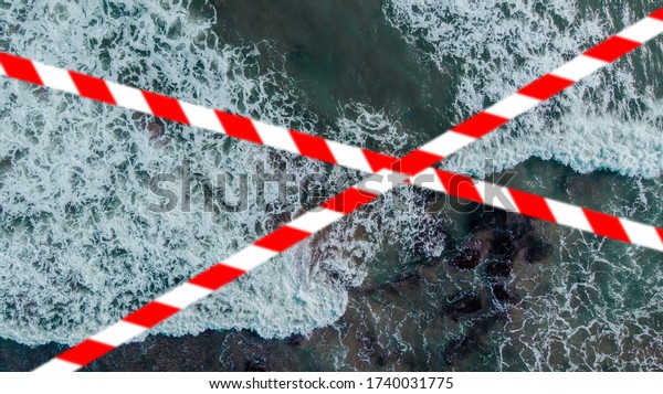 Barrier tape - quarantine, isolation, entry\
ban. Do not cross. Top view of the sea\
shore