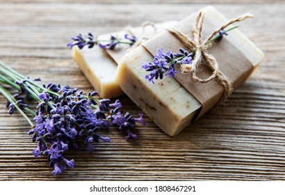 Bars of handmade soap with lavender flowers over  wood grunge background.