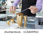 Bartender is adding ingredient in shaker at bar counter