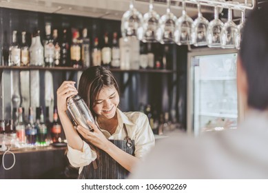 Bartender is adding ingredient in shaker at bar counter