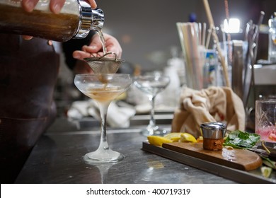 Bartender Coocks Cocktail Behind A Bar Counter