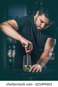 Bartender crushed with a muddler lime for mojito cocktail