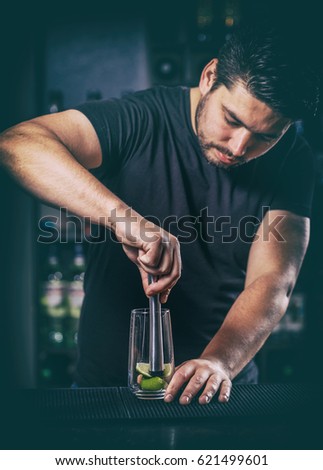 Bartender crushed with a muddler lime for mojito cocktail