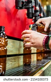 Bartender Hand At Beer Tap Pouring A Draught Beer In Glass In Tap Room