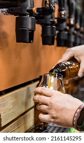 Bartender Hand At Beer Tap Pouring A Draught Beer In Glass In Tap Room