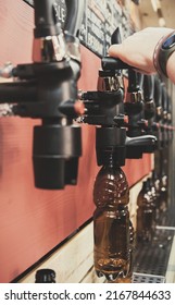 Bartender Hand At Beer Tap Pouring A Draught Beer In Bottle In Tap Room