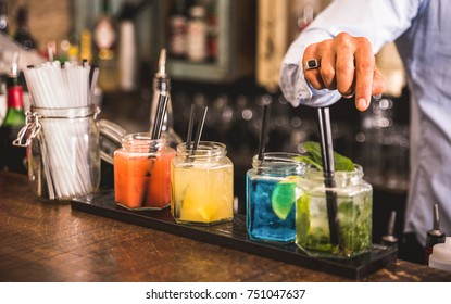 Bartender Hand At Multicolored Fashion Drink With Straw On Vintage Glass Cups In Fashion Cocktail Bar - Food And Beverage Concept With Professional Barman Working At Mixology Restaurant - Vivid Colors