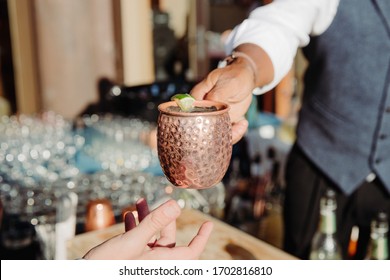 A Bartender Hands A Moscow Mule Mixed Alcoholic Drink In A Copper Moscow Mule Mug On A Sunny Day To A Wedding Attendee