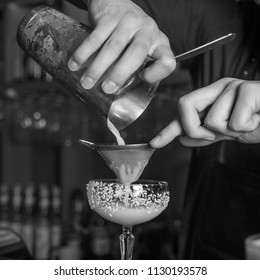 The Bartender Makes A Cocktail Of Coconut And Ice. Macro, Black Background, Hand, White