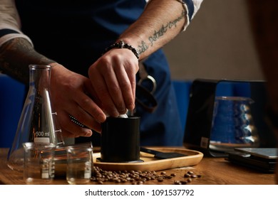 Bartender making alternative coffee using manual drip brewer, barista pouring water from kettle 