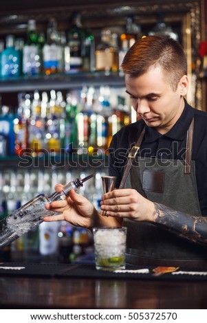 The bartender making cocktail in a nightclub bar