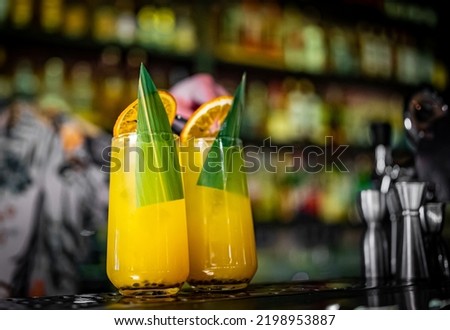 bartender making cocktail with passion fruit in a nightclub bar