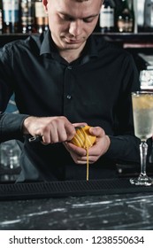 Bartender Making Cocktail. Slicing A Long Ribbon Of Lemon Peel