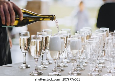 A Bartender, A Man Pours Alcohol From A Bottle, Champagne Into Glasses. Wedding Photography.