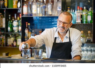 Bartender Man Pours Whiskey To The Client Of The Hotel Bar. The Concept Of Service. Focus On The Bartender.