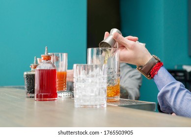 Bartender mischt einen Cocktail in einem Shaker und gießt ihn. Einen Cocktail machen. Mixologie