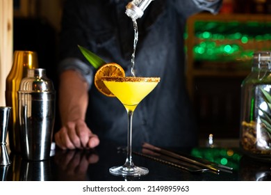 Bartender Pouring Alcohol On A Cocktail In A Night Club Bar