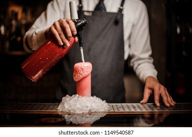 Bartender Pouring Alcoholic Sparkling Water Into A Glass With Sweet Red Berry Summer Cocktail With Foam On The Bar Counter